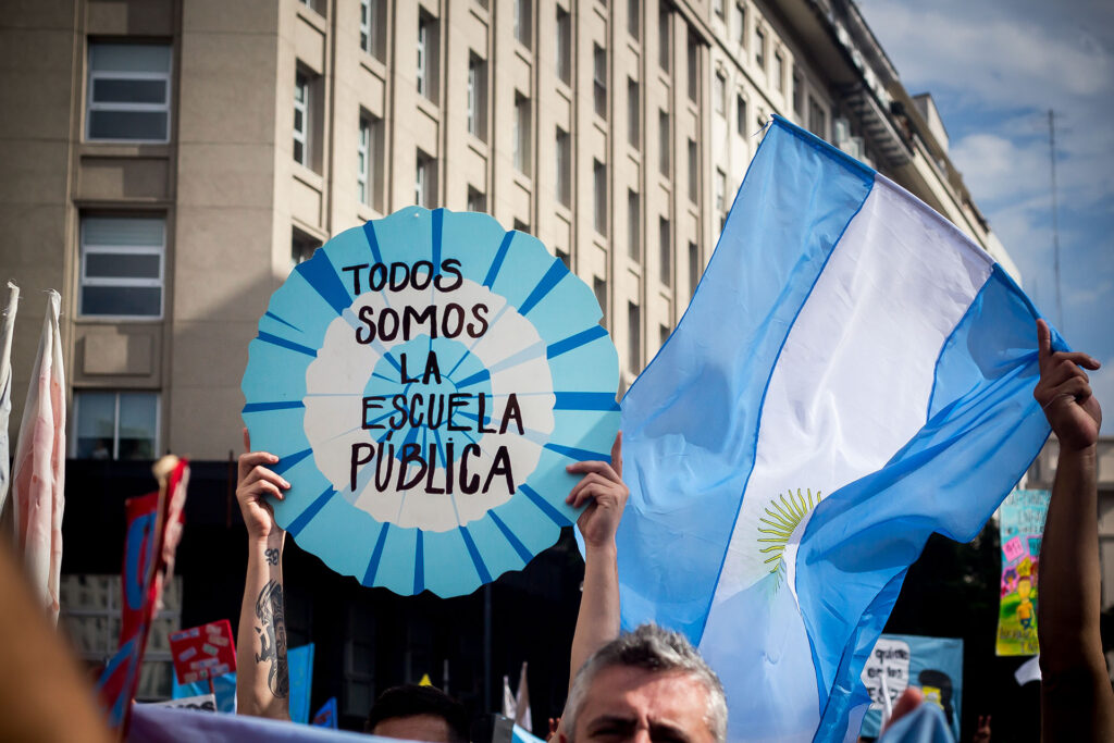 Cartel de escarapela que dice "Todos somos la escuela pública" - Foto de Ezequiel Glikman